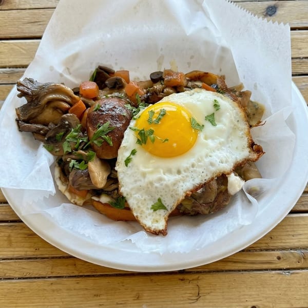 Savory breakfast dish with mushrooms, carrots, and a fried egg, garnished with parsley.